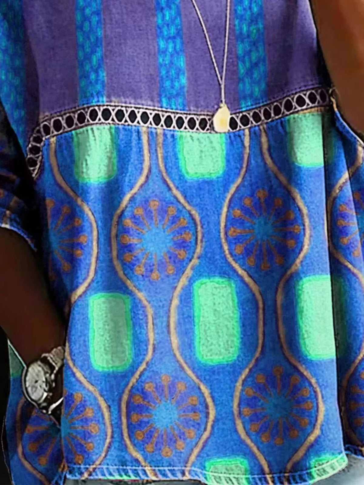 Plus Size Hollow Out Top featuring stylish lace detail and vibrant geometric patterns in purple and green.