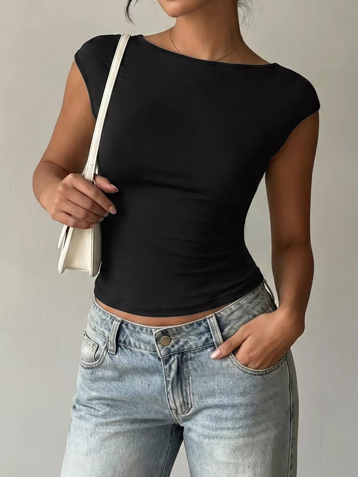Lace Detail Cap-Sleeve T-Shirt in black worn with casual jeans and a stylish handbag.
