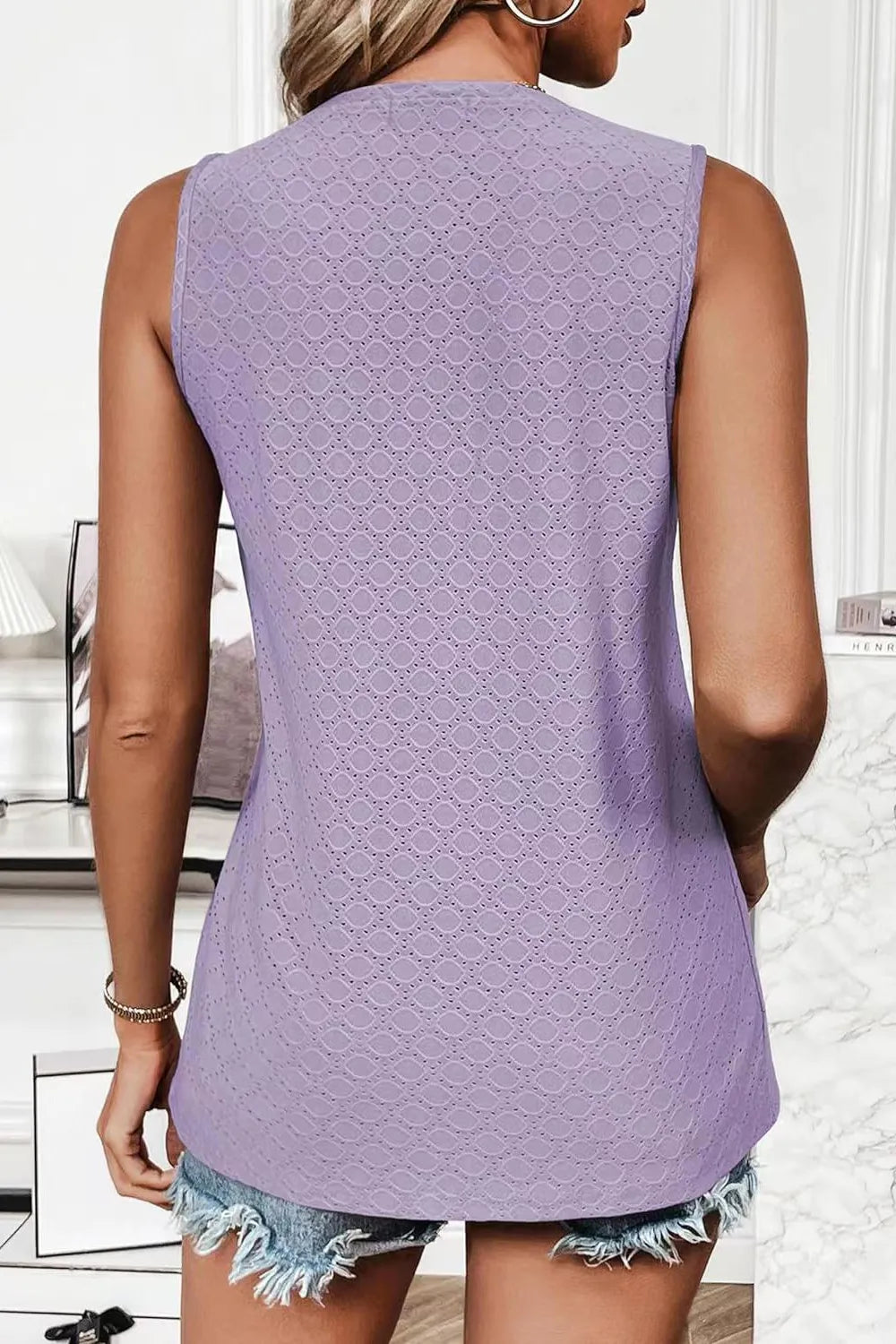 Back view of a woman wearing an Eyelet Round Neck Tank in purple, showcasing the stylish design and sleeveless cut.