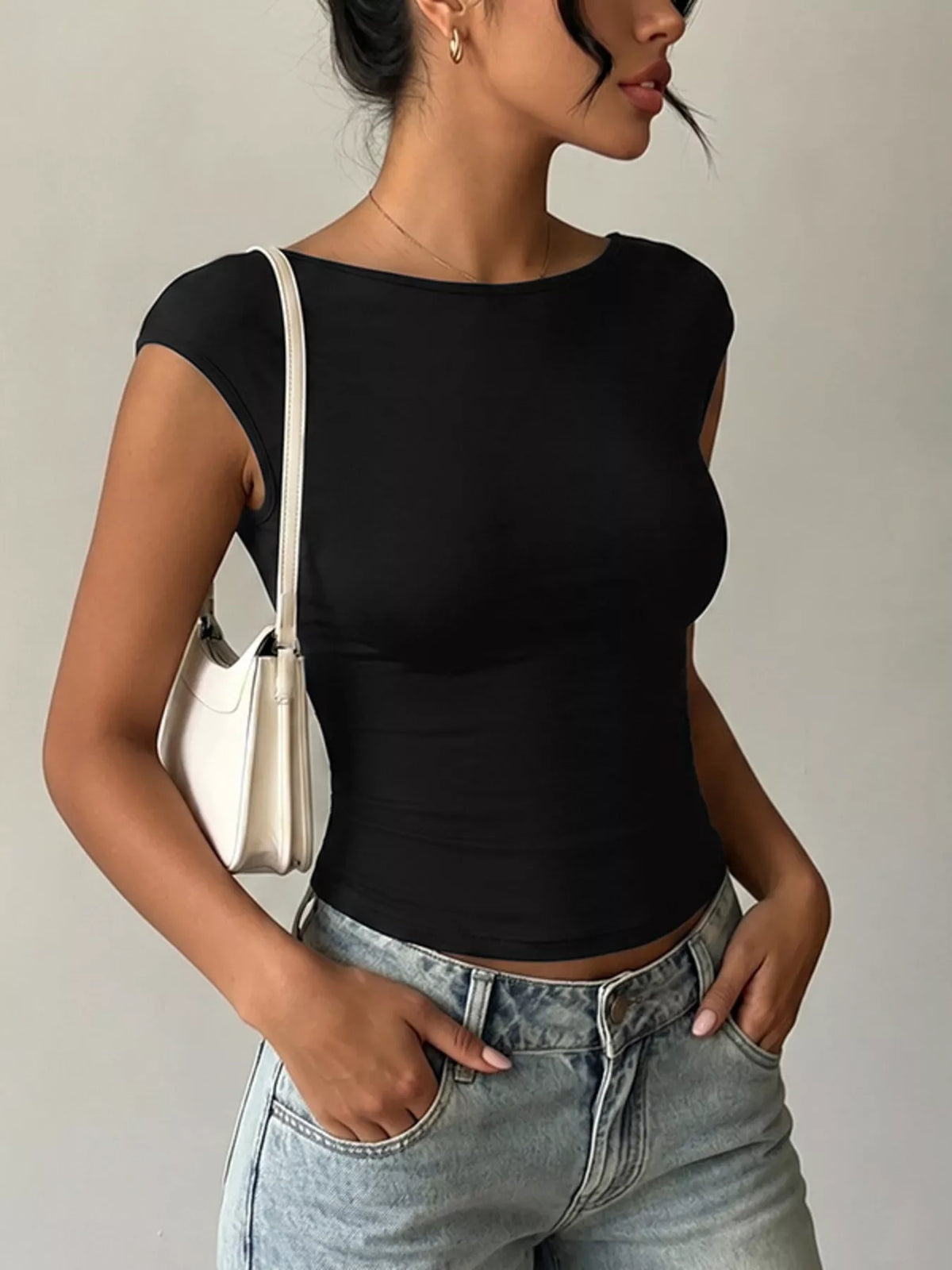 Model wearing a Lace Detail Cap-Sleeve T-Shirt with a black design and casual jeans.