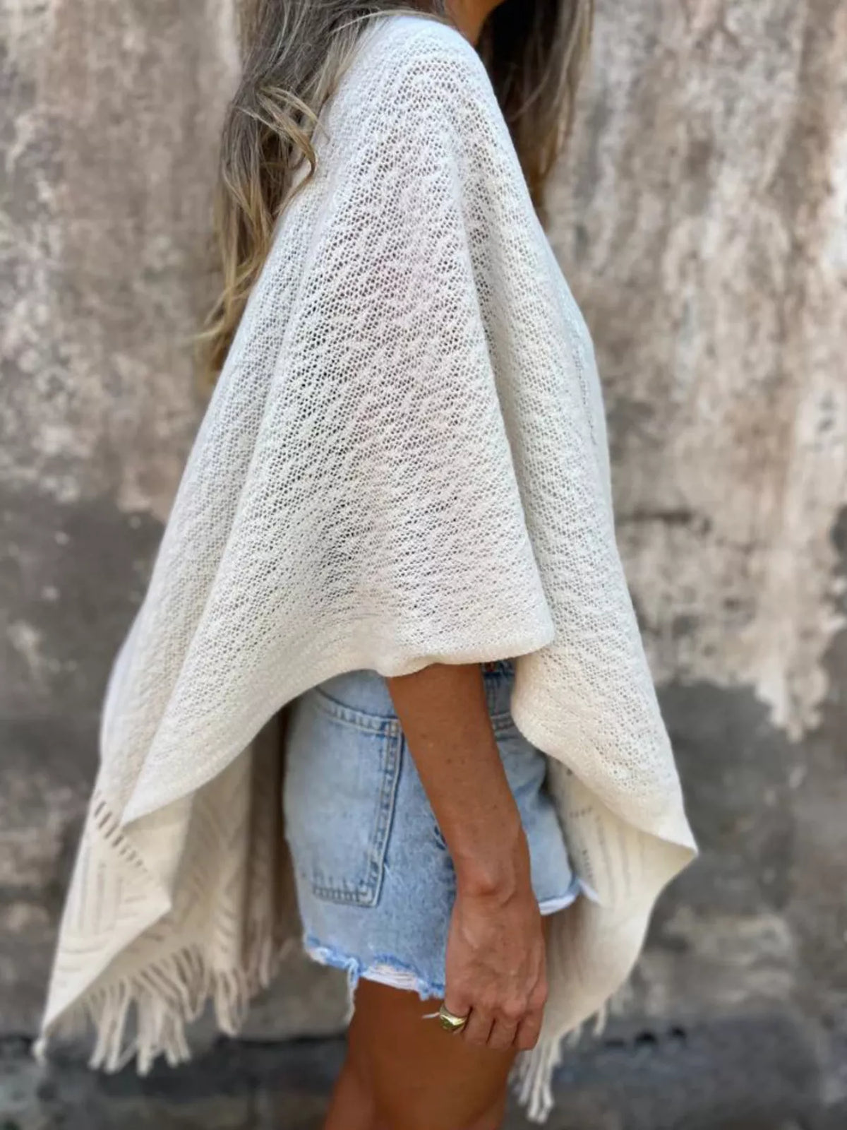 Fringe Open Front Cardigan worn by a woman, styled with denim shorts and a black top, showcasing its chic and comfortable design.