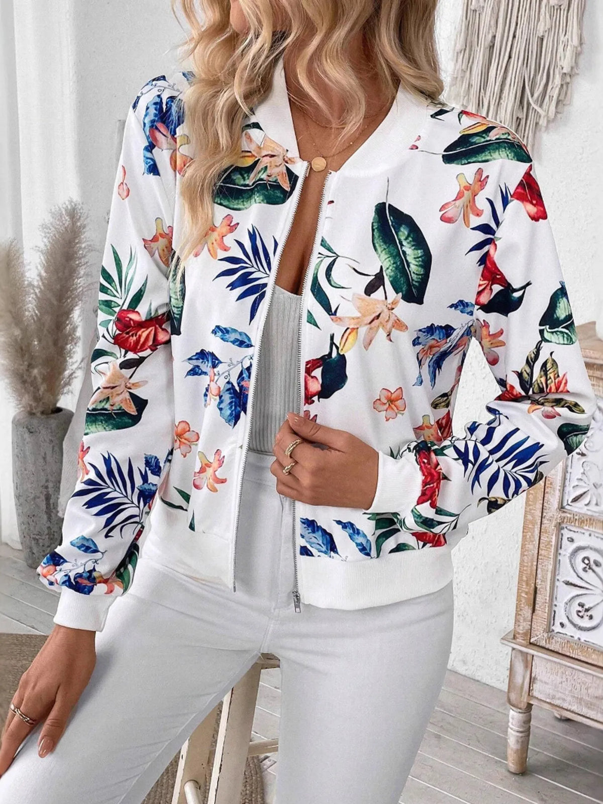 Printed Zip Up Jacket featuring vibrant floral print, styled with casual white outfit and clutch bag.