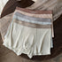 Mens thermal underwear in a 3-pack featuring warm fleece shorts in coordinated colors on a wooden surface.