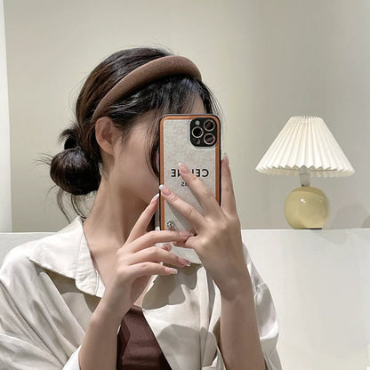 A woman wearing a Solid Color Knit Hair Headband while taking a selfie with her phone.