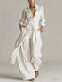 Back view of a woman wearing a Long-Sleeve Waist-Tie Jumpsuit in brown, showcasing its elegant design.