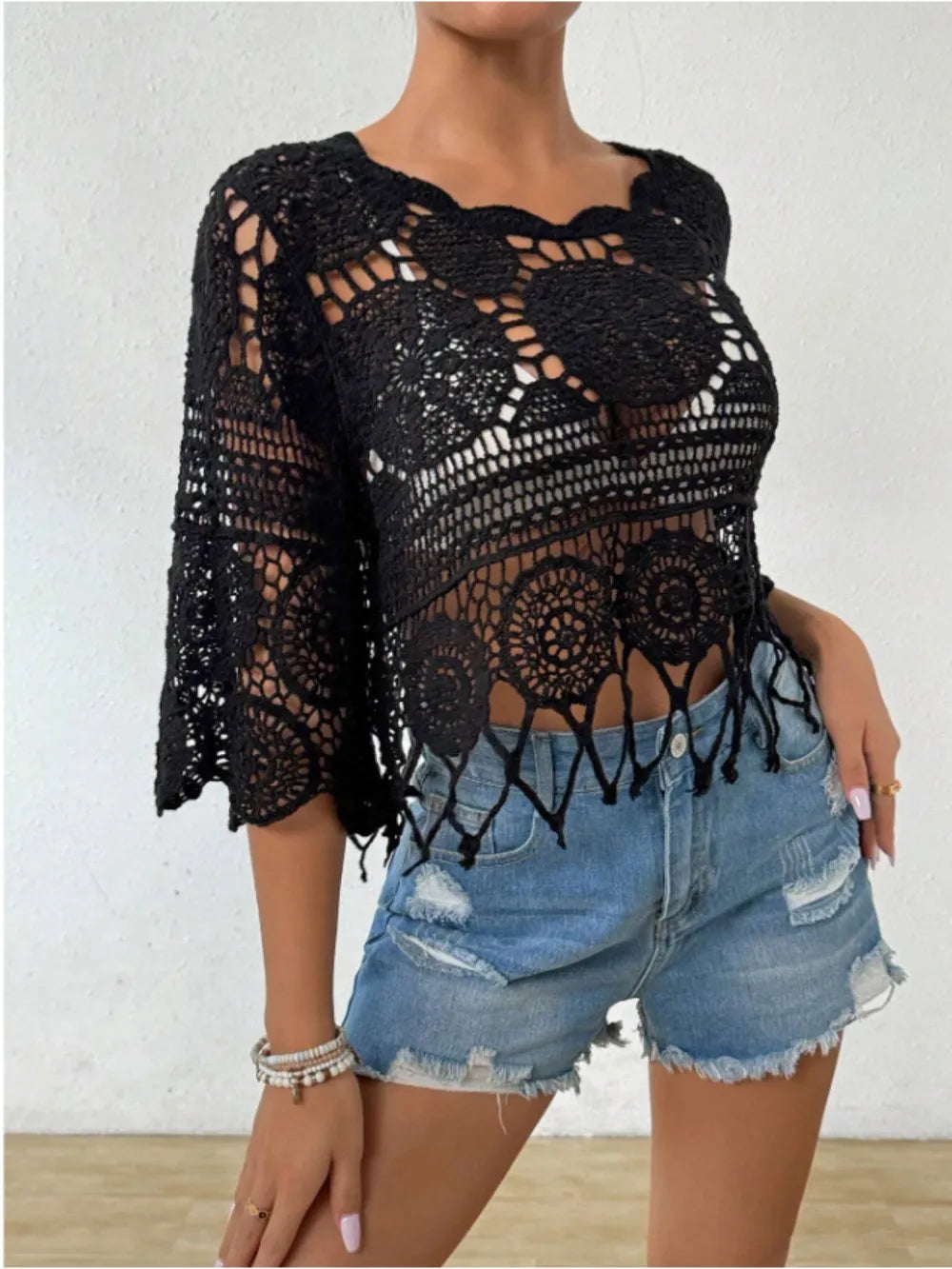 Model showcasing an openwork round neck cover-up paired with denim shorts, perfect for summer styling.