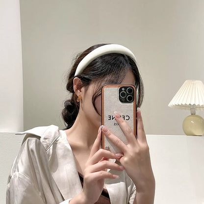 A woman wearing a Solid Color Knit Hair Headband while taking a selfie with her phone.