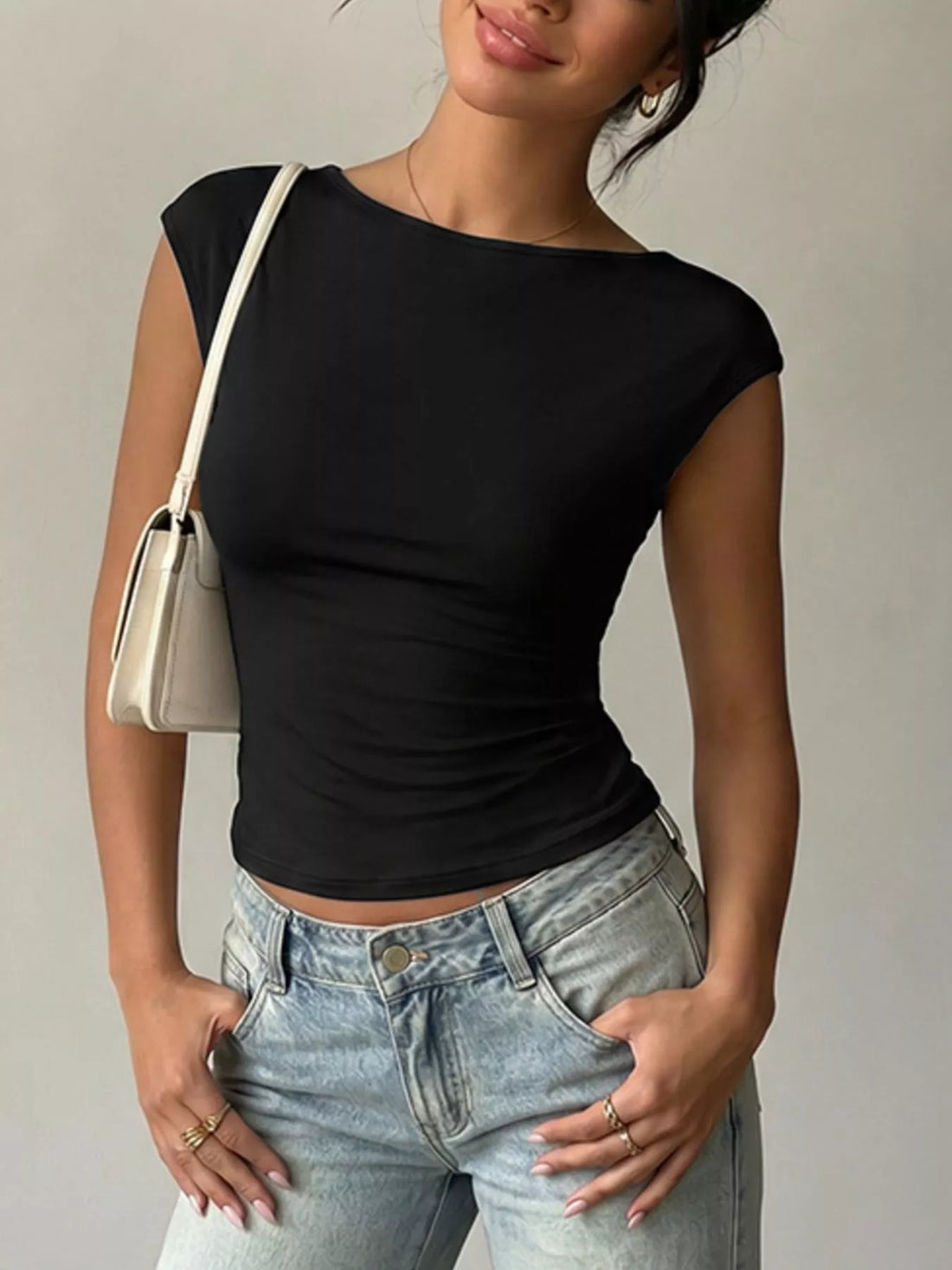 Lace Detail Cap-Sleeve T-Shirt in black worn with casual jeans and a stylish handbag.