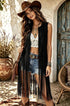 Woman wearing a Vintage Tassel Vest Cardigan in pink, styled with denim shorts and accessories, posing outdoors.