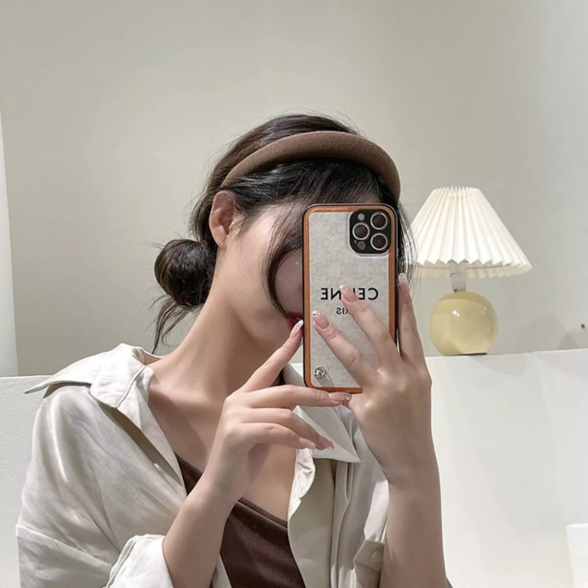 A woman wearing a Solid Color Knit Hair Headband while taking a selfie with her phone.
