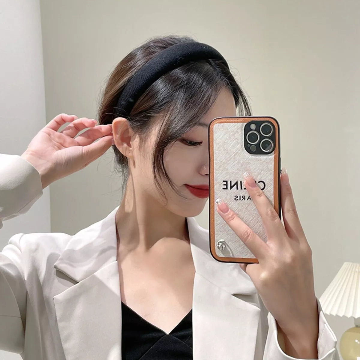 A woman wearing a Solid Color Knit Hair Headband while taking a selfie with her phone.