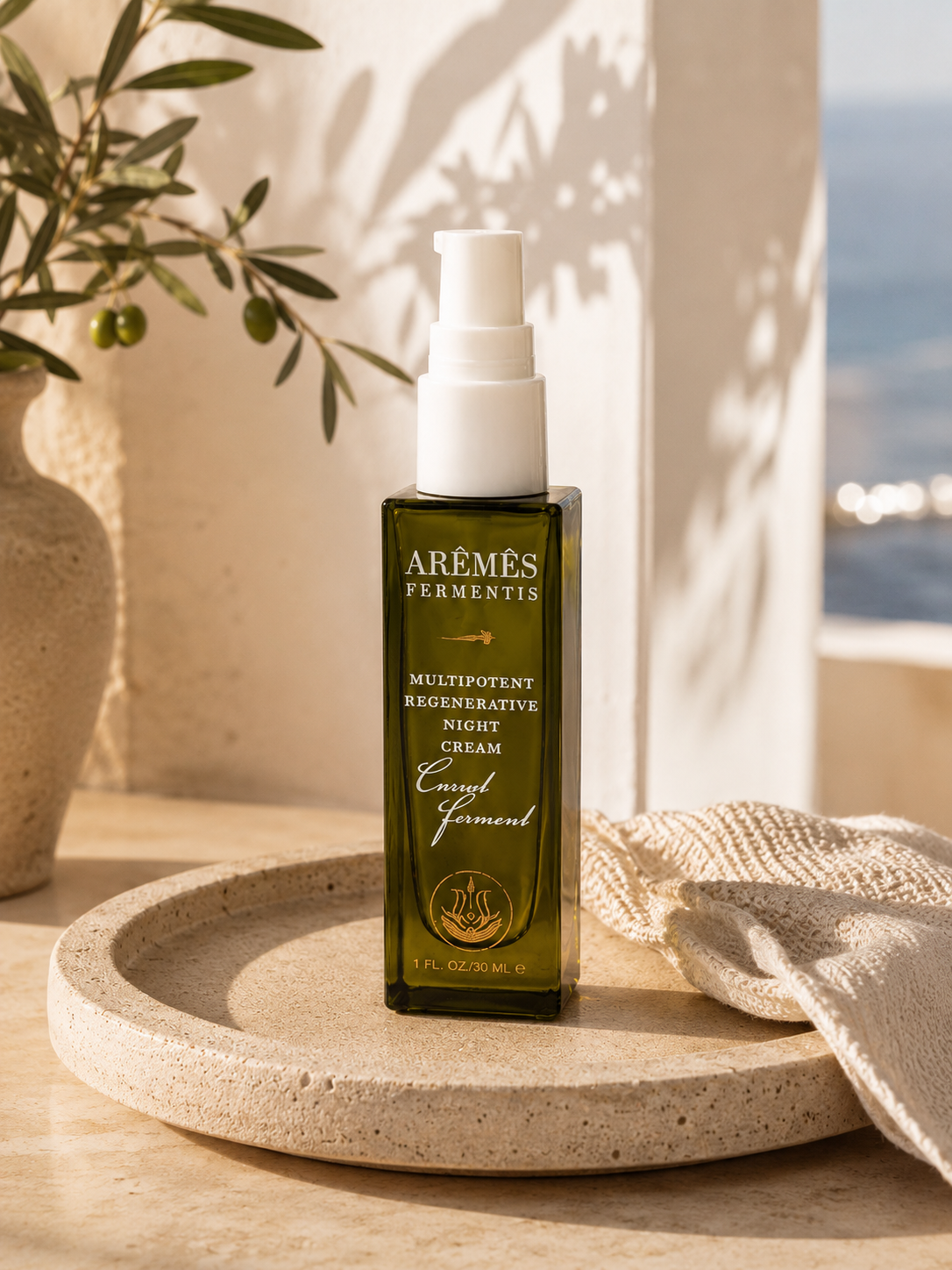 Multipotent Night Cream displayed in an elegant bottle on a stone tray for overnight skin rejuvenation.