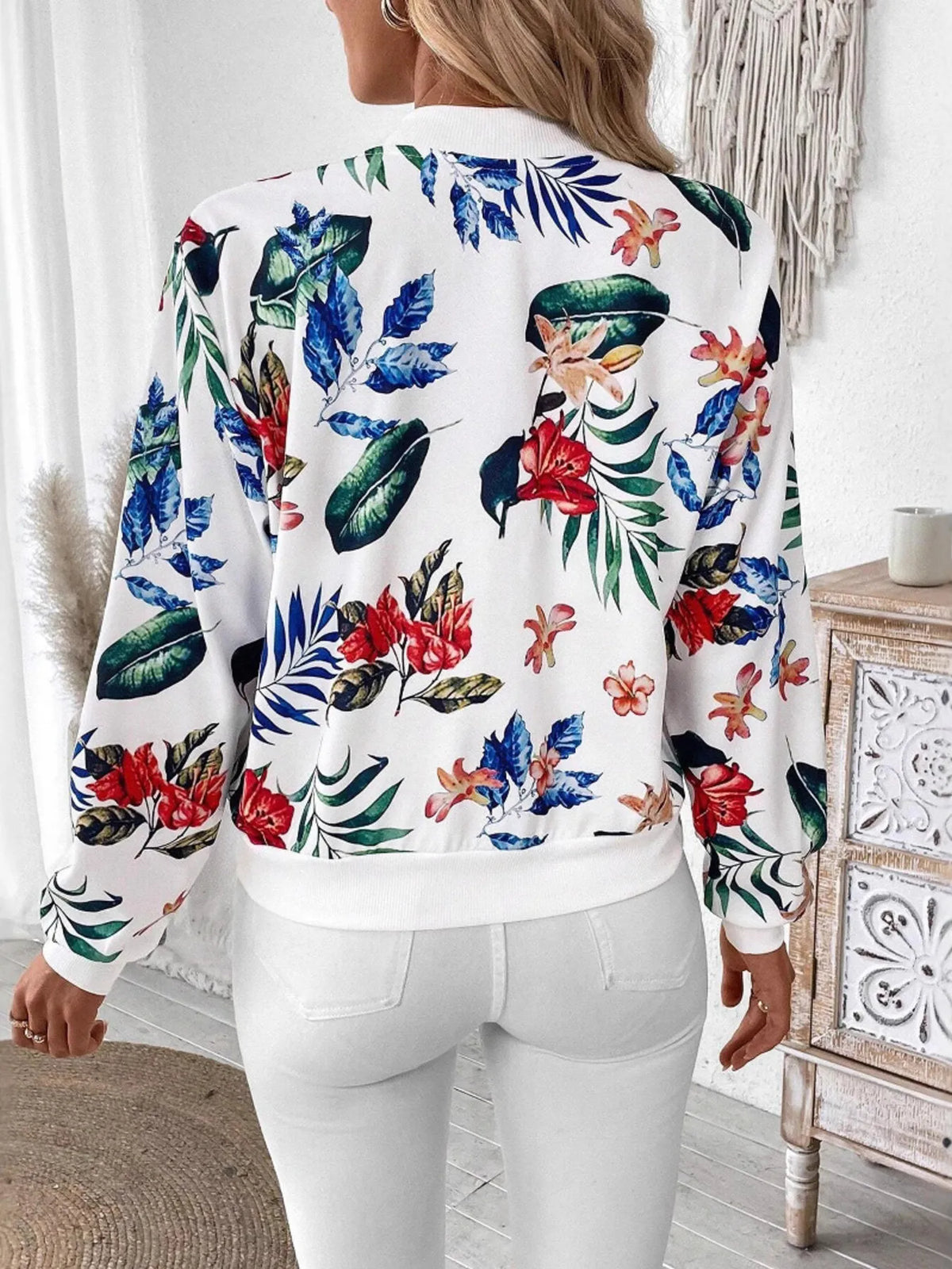 Printed Zip Up Jacket featuring vibrant floral print, styled with casual white outfit and clutch bag.