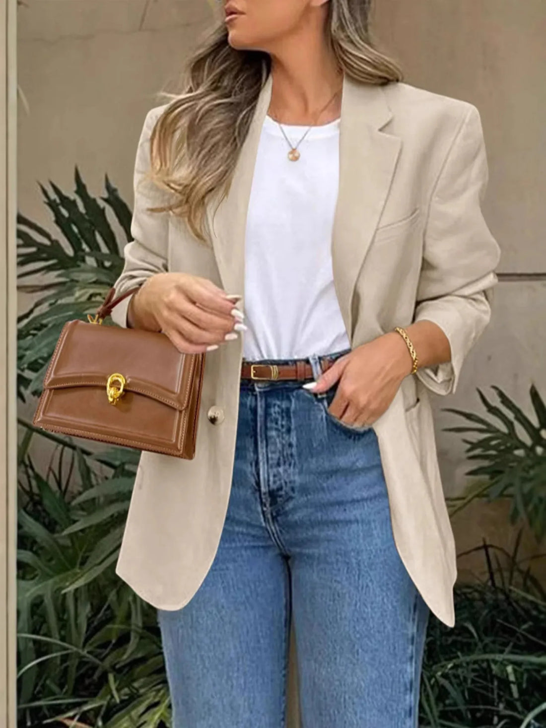 Model wearing a Pocketed Lapel Collar Long Sleeve Blazer with jeans and a stylish handbag.