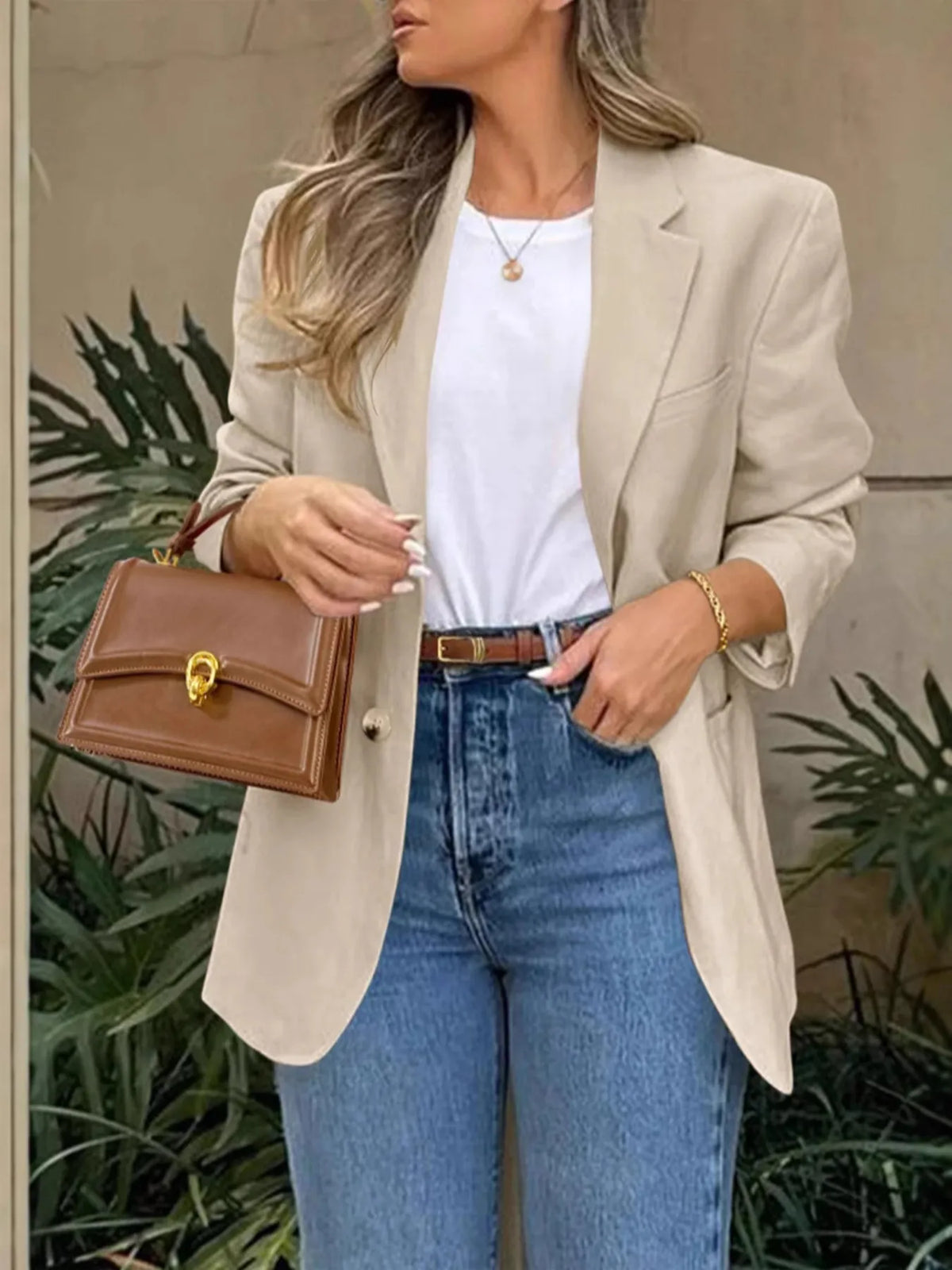 Model wearing a Pocketed Lapel Collar Long Sleeve Blazer with jeans and a stylish handbag.