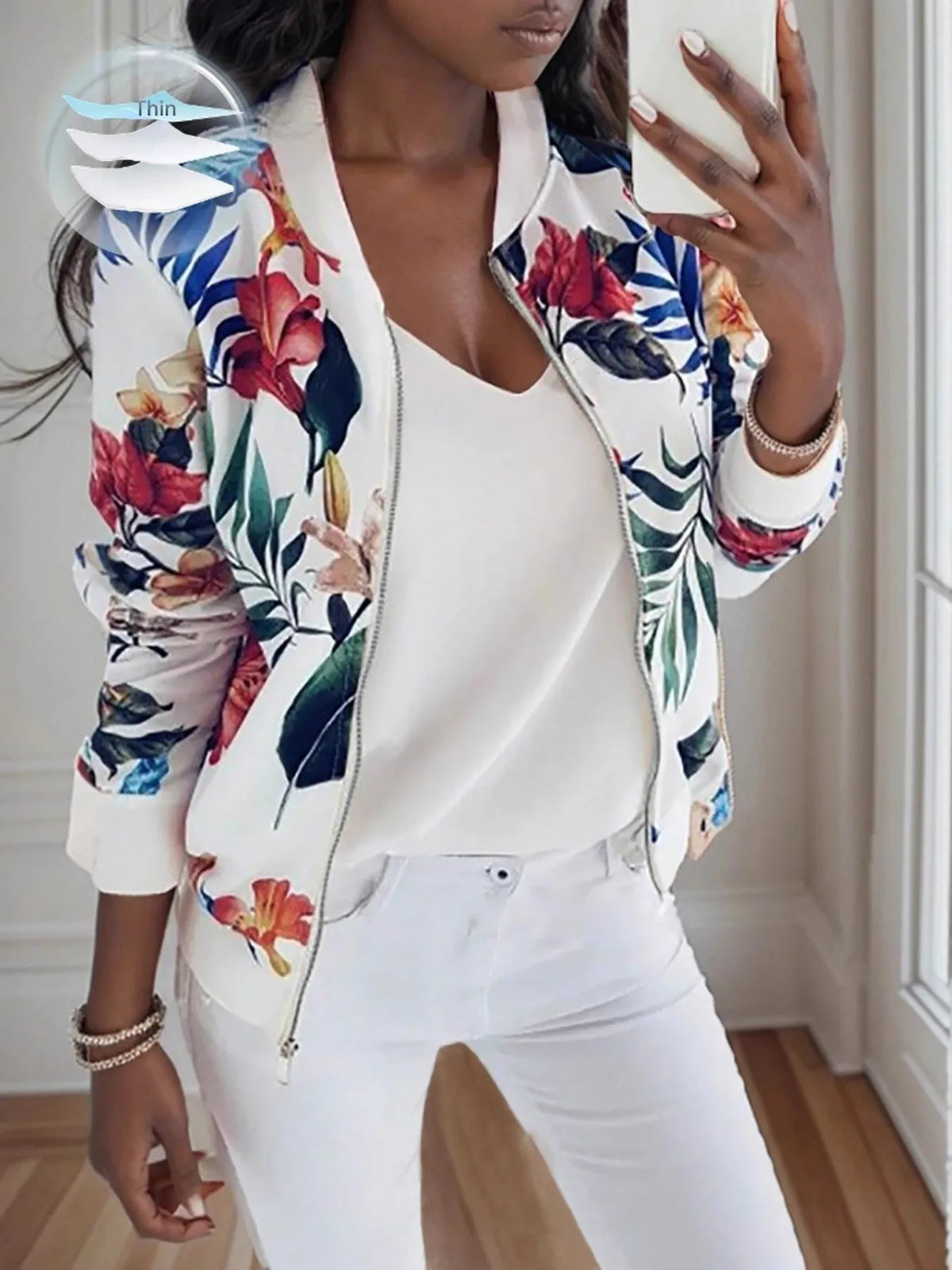Printed Zip Up Jacket featuring vibrant floral print, styled with casual white outfit and clutch bag.