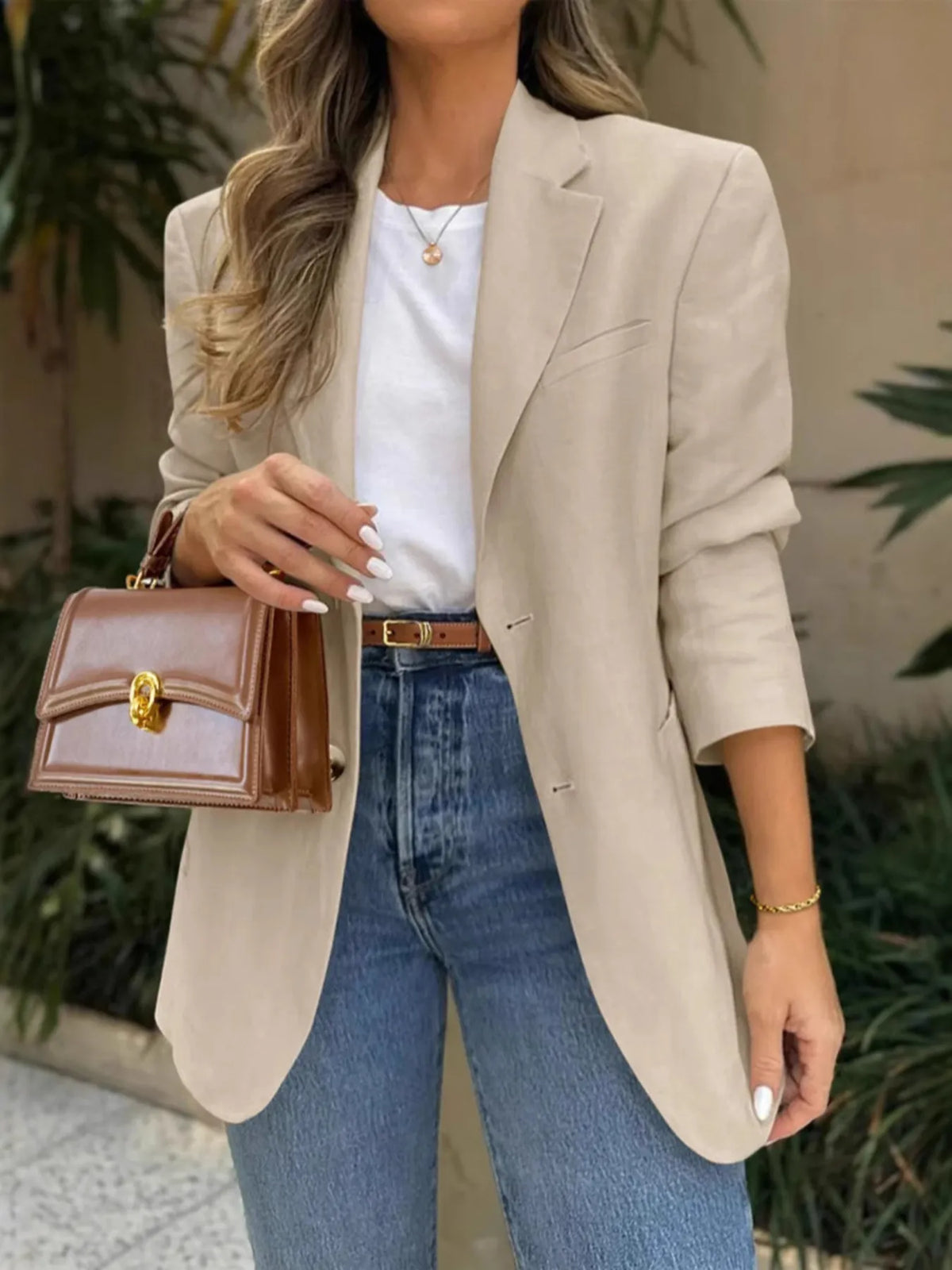 Model wearing a Pocketed Lapel Collar Long Sleeve Blazer with jeans and a stylish handbag.