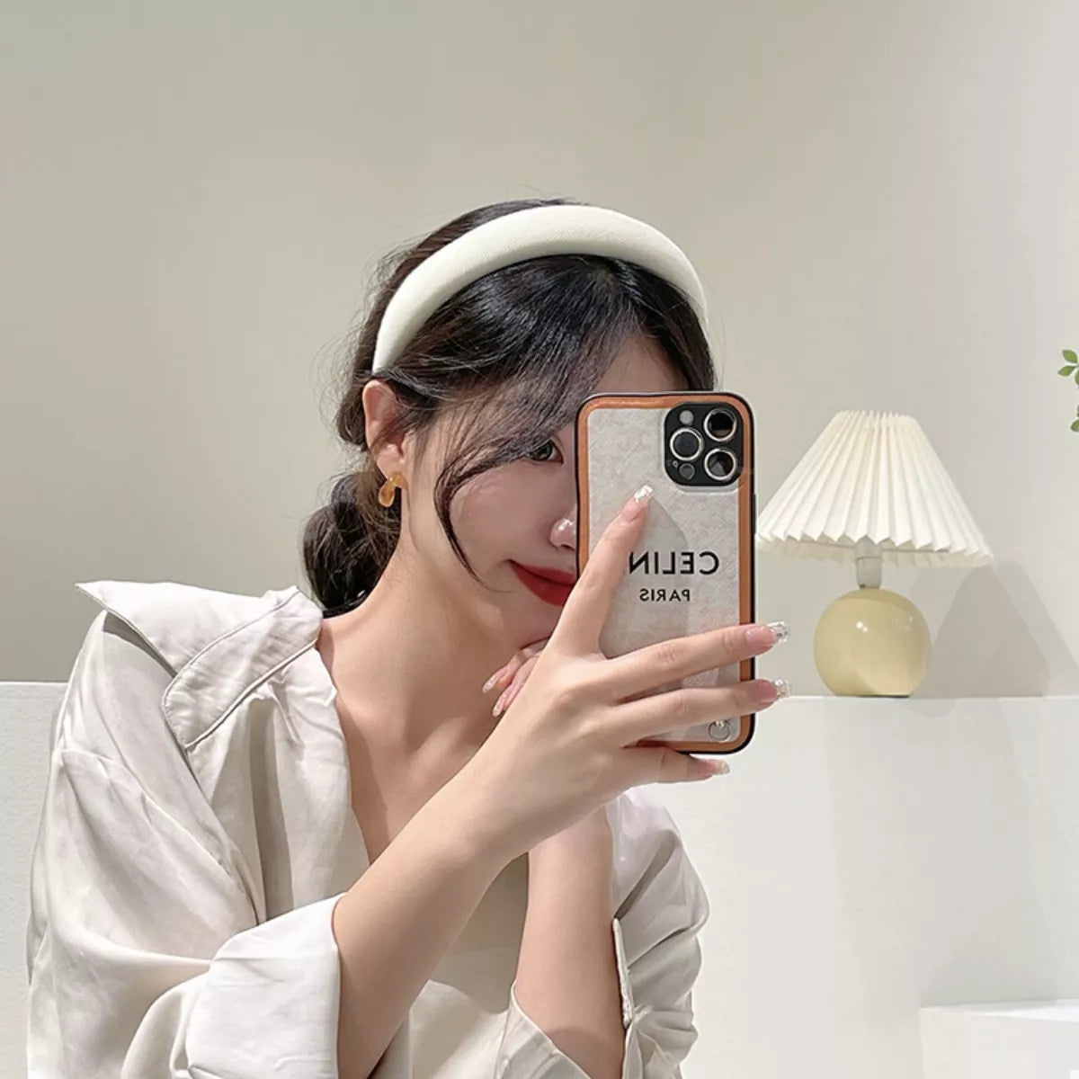 A woman wearing a Solid Color Knit Hair Headband while taking a selfie with her phone.