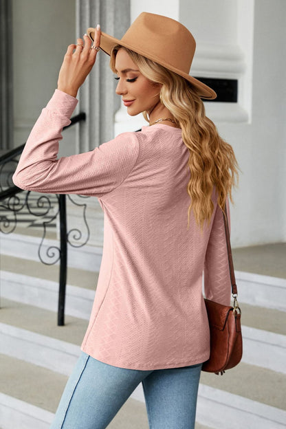 Stylish woman wearing a Notched Neck Buttoned Blouse with long sleeves and a hat, showcasing casual elegance.